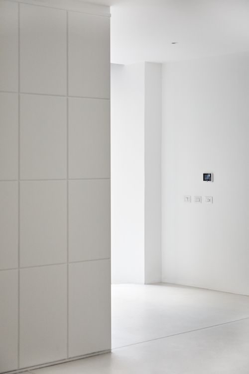 Strak afgewerkte woonkamer met gladde witte wanden, het soort eindresultaat dat je bij eerder werk mag verwachten
