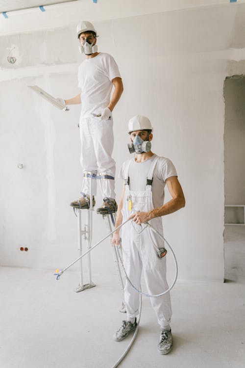 Twee vaklieden die samenwerken aan wandafwerking in een verbouwde woning