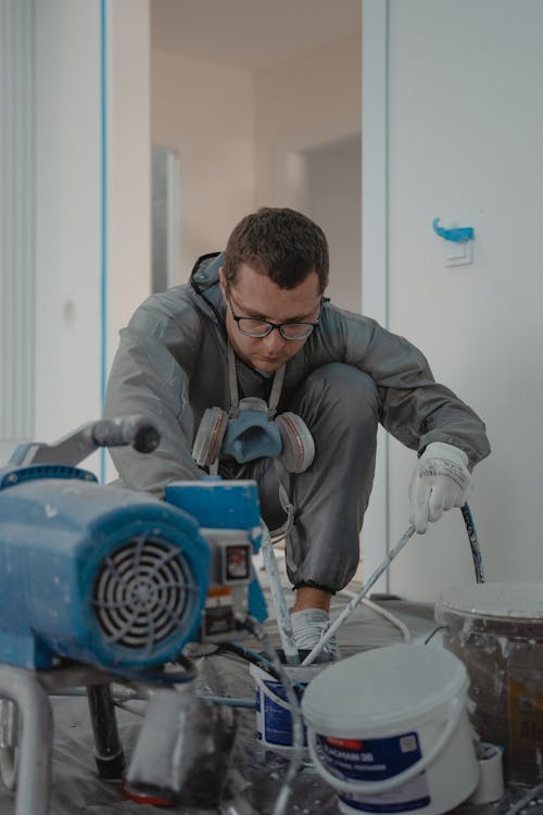 Man die een binnenmuur schildert met een verfroller tijdens renovatie
