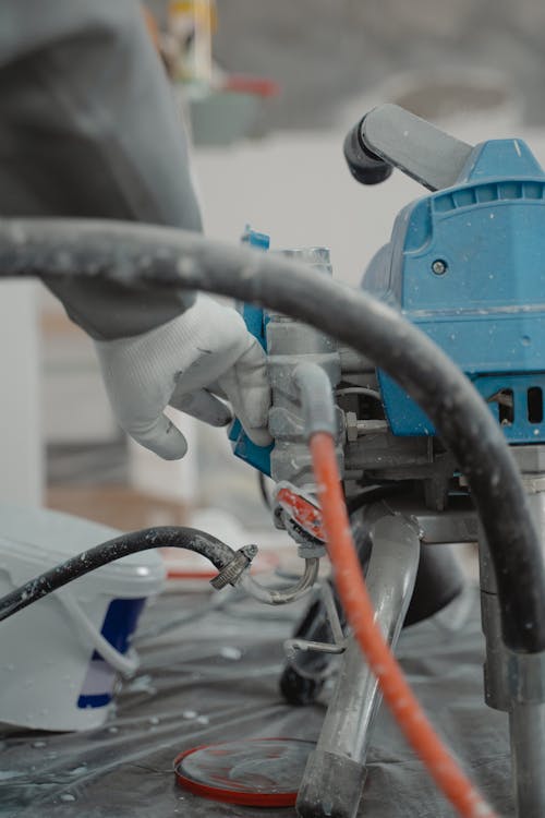 Vakman die een verfspuitmachine bedient bij een binnenrenovatie in Tilburg