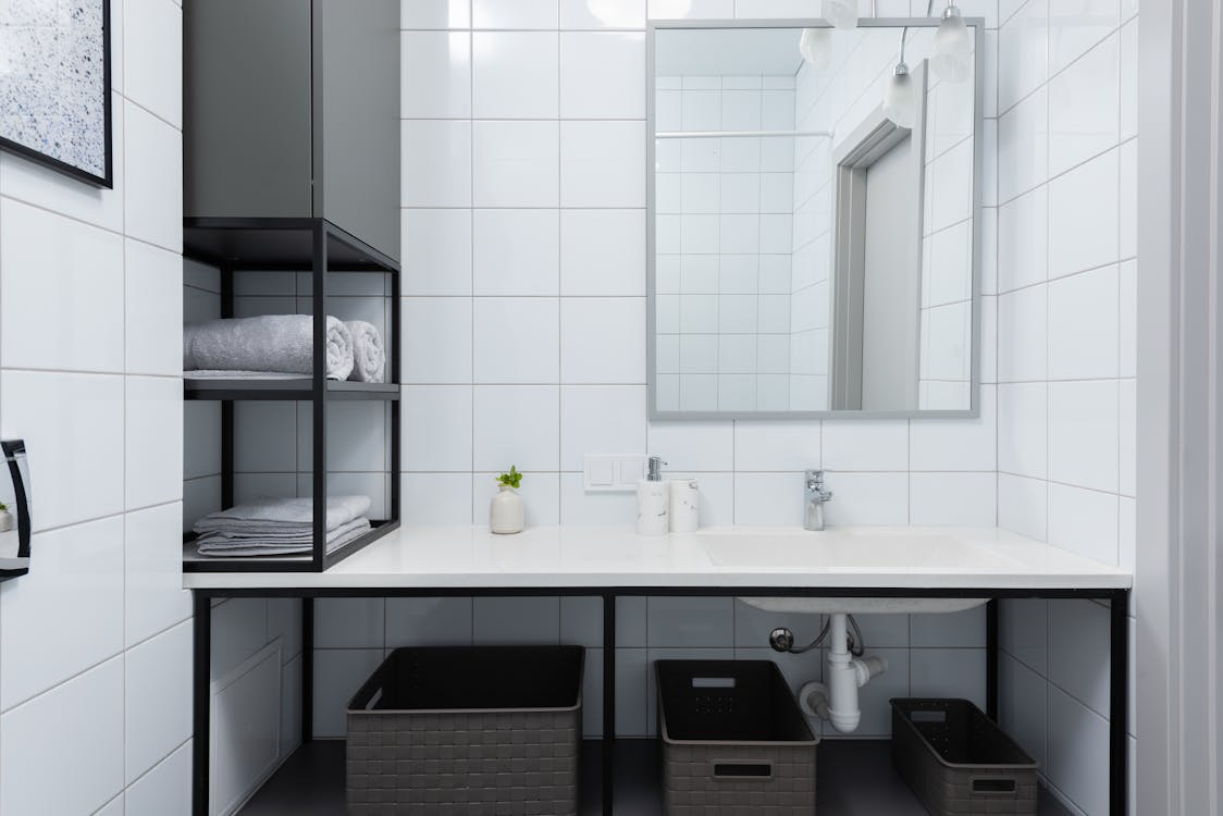Moderne badkamer met strak afgewerkte wanden in betonlook stijl en spiegel
