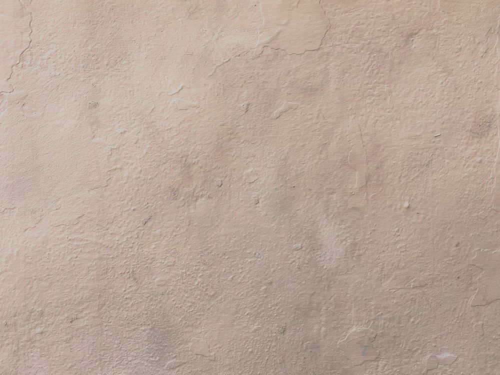Getextureerde beige sierpleisterwand met zichtbare korrelstructuur