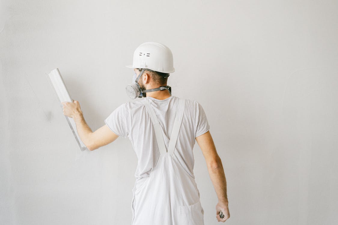 Bouwvakker die een muur bewerkt in een woning tijdens een verbouwing