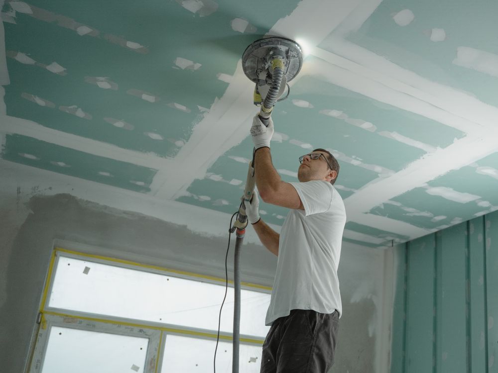Bouwvakker die het plafond schuurt tijdens een renovatieproject in Tilburg